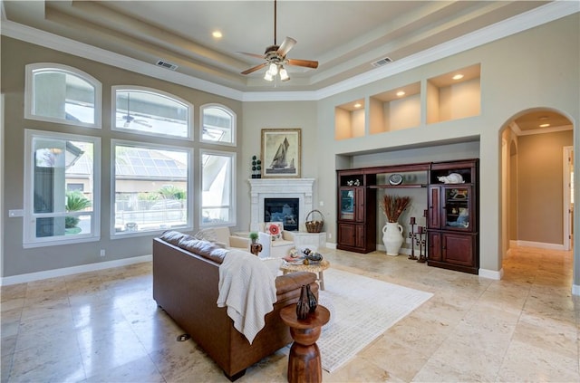 2096 E Olympic Ave, Fresno, CA 93730 - living room with arched walkways, a raised ceiling, a ceiling fan, a glass covered fireplace, and baseboards