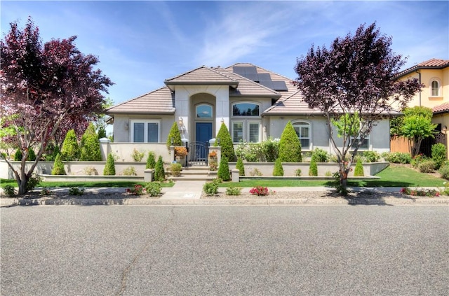 2096 E Olympic Ave, Fresno, CA 93730 - view of front of house featuring a tiled roof, roof mounted solar panels, and stucco siding