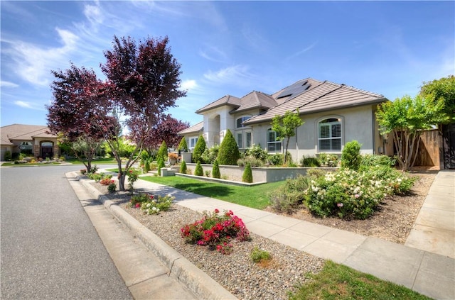 2096 E Olympic Ave, Fresno, CA 93730 - view of front of property with roof mounted solar panels, a tiled roof, and stucco siding