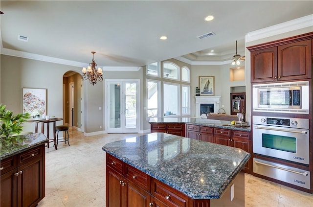 2096 E Olympic Ave, Fresno, CA 93730 - kitchen with stainless steel appliances, a warming drawer, a chandelier, arched walkways, and crown molding