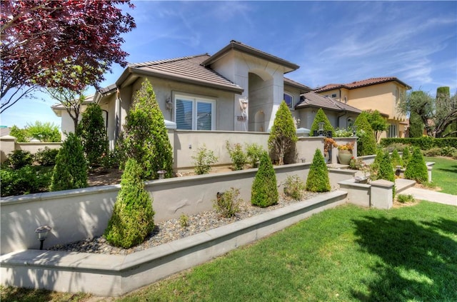 2096 E Olympic Ave, Fresno, CA 93730 - view of front facade featuring a tile roof, stucco siding, and a front lawn