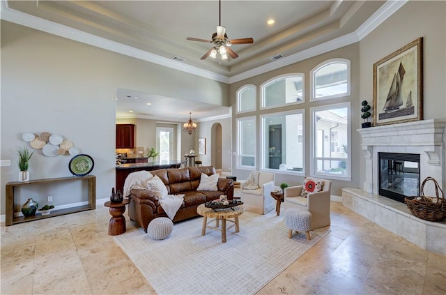 2096 E Olympic Ave, Fresno, CA 93730 - living area featuring a tray ceiling, a premium fireplace, crown molding, ceiling fan, and arched walkways