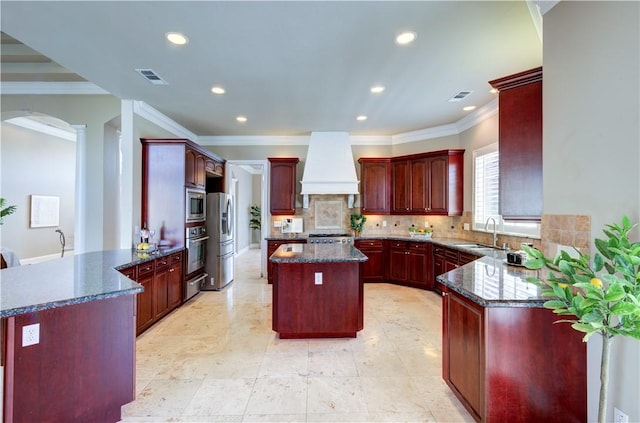 2096 E Olympic Ave, Fresno, CA 93730 - kitchen featuring premium range hood, stainless steel appliances, a sink, reddish brown cabinets, and ornamental molding