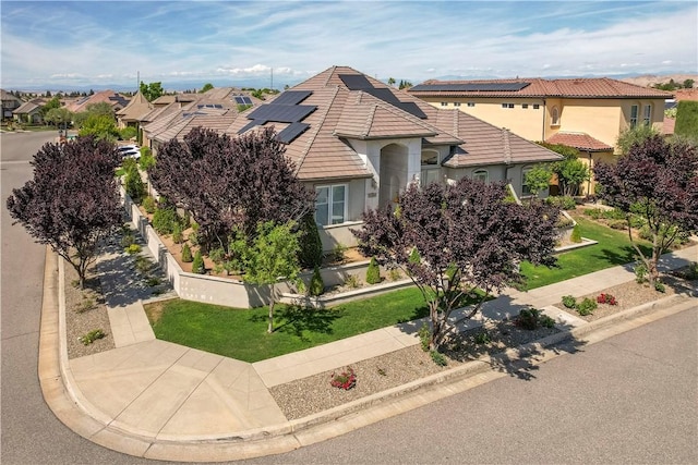 2096 E Olympic Ave, Fresno, CA 93730 - view of front of property featuring stucco siding, roof mounted solar panels, a tiled roof, and a residential view