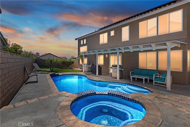 16462 Sun Summit Dr, Riverside, CA 92503 - pool at dusk featuring a patio, a fenced backyard, a pool with connected hot tub, an outdoor living space, and area for grilling