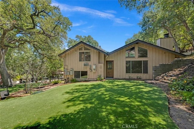 8402 Mcgroarty St, Sunland, CA 91040 - back of property featuring a chimney, board and batten siding, and a lawn