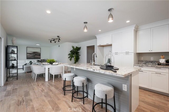 20619 Entradero Ave, Torrance, CA 90503 - kitchen featuring white cabinets, light wood-style flooring, light stone countertops, a sink, and recessed lighting