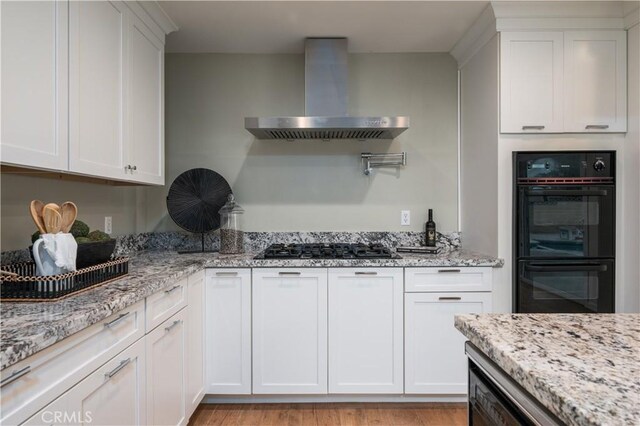 20619 Entradero Ave, Torrance, CA 90503 - kitchen with wall chimney exhaust hood, gas stovetop, white cabinets, light stone countertops, and light wood-type flooring
