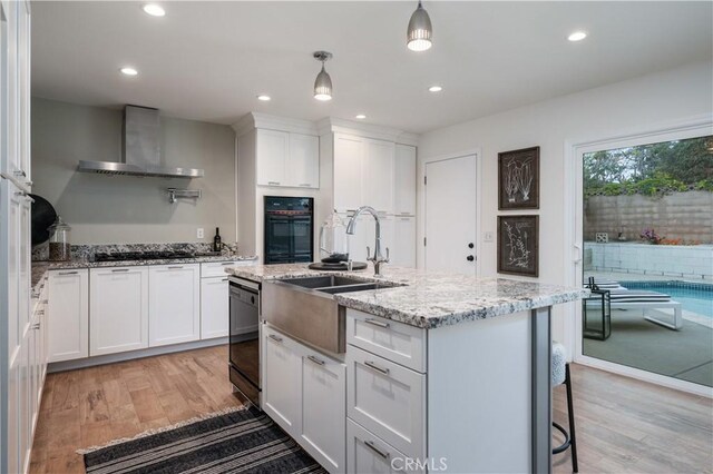20619 Entradero Ave, Torrance, CA 90503 - kitchen featuring wall chimney exhaust hood, black appliances, light wood-style floors, white cabinets, and recessed lighting
