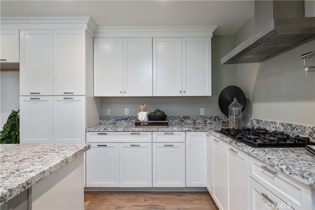 20619 Entradero Ave, Torrance, CA 90503 - kitchen featuring wall chimney exhaust hood, black gas stovetop, white cabinetry, light wood finished floors, and light stone countertops