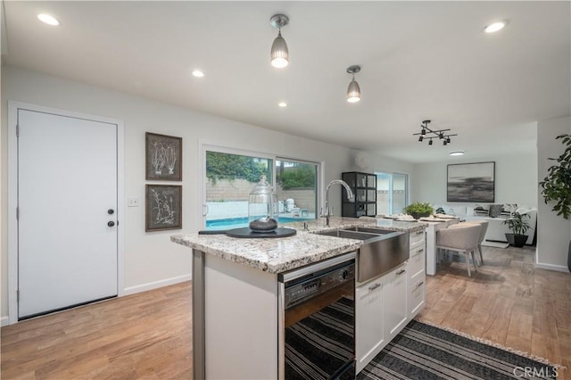 20619 Entradero Ave, Torrance, CA 90503 - kitchen with black dishwasher, a sink, white cabinets, light wood-style floors, and recessed lighting