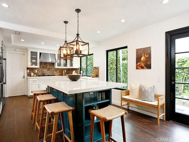 28021 Camino Santo Domingo, San Juan Capistrano, CA 92675 - kitchen with wall chimney range hood, white cabinetry, light countertops, tasteful backsplash, and plenty of natural light