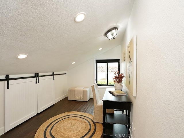 28021 Camino Santo Domingo, San Juan Capistrano, CA 92675 - hall with lofted ceiling, dark wood finished floors, a textured ceiling, a barn door, and baseboards