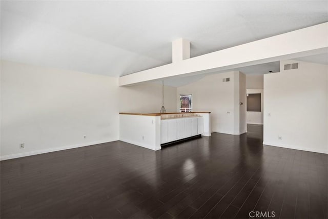 24851 Seagate Dr, Dana Point, CA 92629 - unfurnished living room with dark wood-style flooring, vaulted ceiling, and baseboards