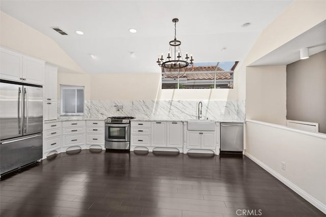24851 Seagate Dr, Dana Point, CA 92629 - kitchen featuring appliances with stainless steel finishes, a sink, dark wood finished floors, white cabinetry, and vaulted ceiling