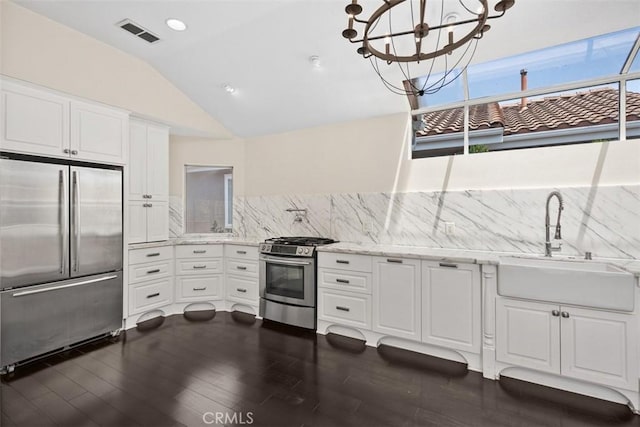 24851 Seagate Dr, Dana Point, CA 92629 - kitchen with stainless steel appliances, a sink, decorative backsplash, dark wood finished floors, and lofted ceiling