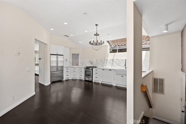 24851 Seagate Dr, Dana Point, CA 92629 - kitchen with stainless steel appliances, white cabinets, light countertops, a chandelier, and vaulted ceiling