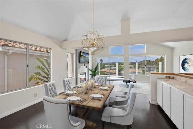 24851 Seagate Dr, Dana Point, CA 92629 - dining space with lofted ceiling, a chandelier, dark wood-style floors, and baseboards