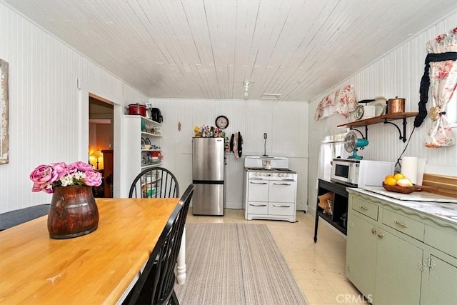 2368 E 107th St, Los Angeles, CA 90002 - kitchen featuring white appliances, green cabinetry, open shelves, light countertops, and wooden walls