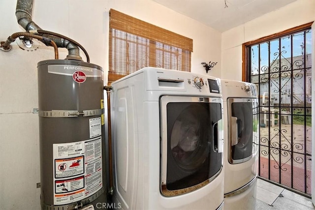 2368 E 107th St, Los Angeles, CA 90002 - washroom with strapped water heater, washer and clothes dryer, and tile patterned floors