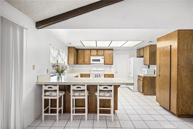 6145 Jasper St, Rancho Cucamonga, CA 91701 - kitchen featuring white appliances, brown cabinets, a peninsula, light countertops, and beam ceiling
