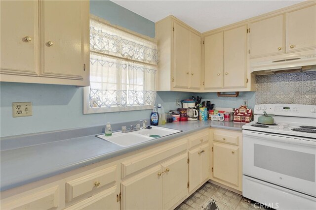 5635 Honeyhill Rd Unit A & B, Oak Hills, CA 92344 - kitchen with electric stove, cream cabinetry, under cabinet range hood, light countertops, and decorative backsplash