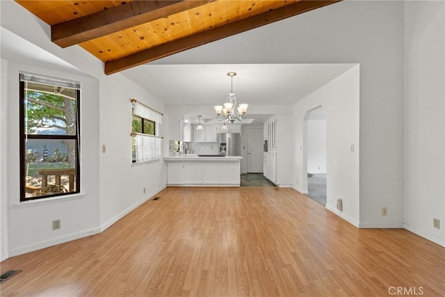 1585 Gate Ln, Paradise, CA 95969 - unfurnished living room featuring a chandelier, light wood-style flooring, arched walkways, and wooden ceiling