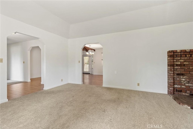 1585 Gate Ln, Paradise, CA 95969 - unfurnished living room featuring carpet flooring, arched walkways, a chandelier, and baseboards