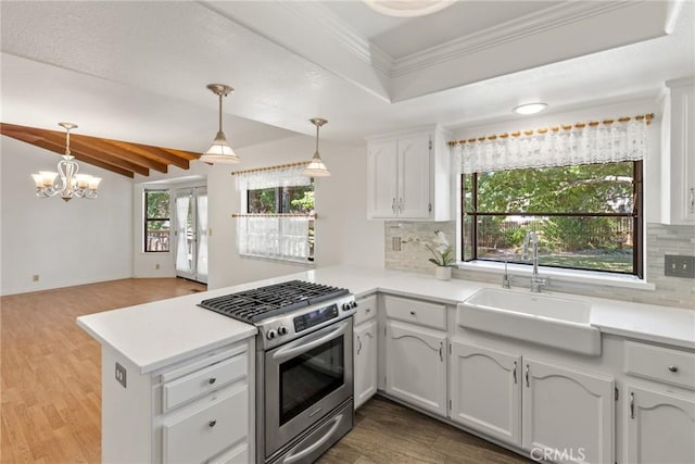1585 Gate Ln, Paradise, CA 95969 - kitchen with stainless steel gas range oven, a peninsula, a sink, decorative backsplash, and white cabinetry