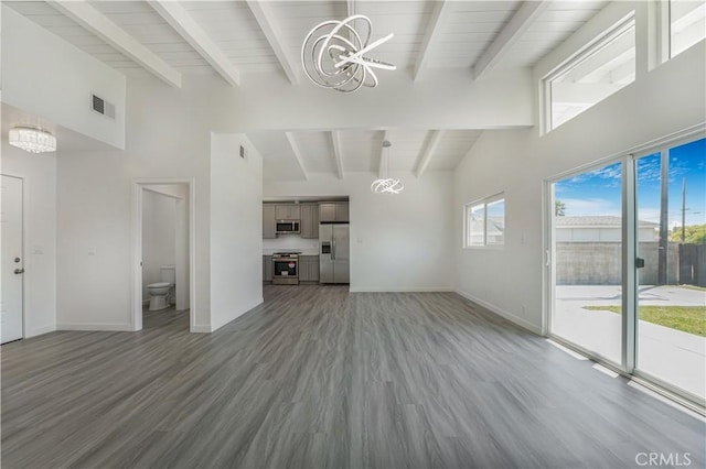 9809 Odessa Ave, North Hills, CA 91343 - unfurnished living room with a chandelier, beamed ceiling, wood finished floors, baseboards, and high vaulted ceiling
