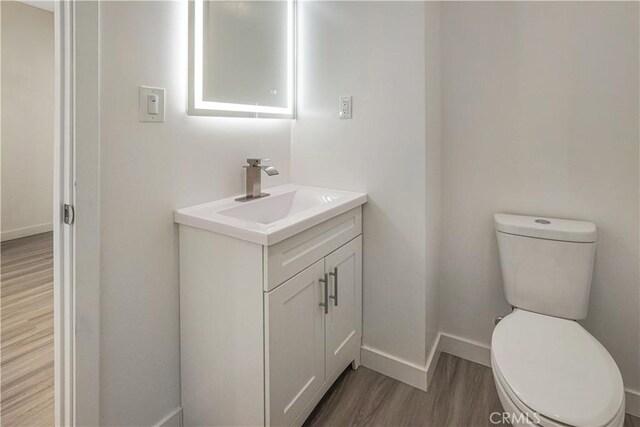 9809 Odessa Ave, North Hills, CA 91343 - half bath featuring wood finished floors, vanity, toilet, and baseboards