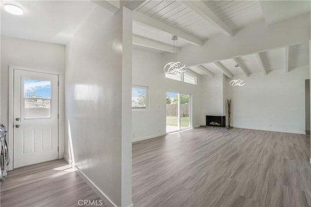 9809 Odessa Ave, North Hills, CA 91343 - unfurnished living room featuring wood finished floors, a chandelier, baseboards, and a brick fireplace