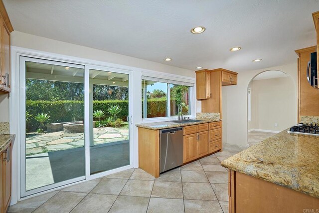 723 Fresca Ct, Solana Beach, CA 92075 - kitchen featuring stainless steel appliances, light stone countertops, arched walkways, recessed lighting, and brown cabinetry
