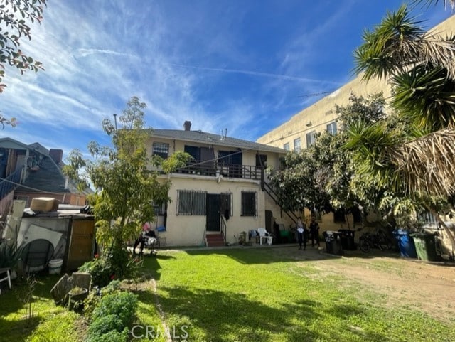 1835 W 12th St, Los Angeles, CA 90006 - rear view of property featuring a balcony, stucco siding, and a yard