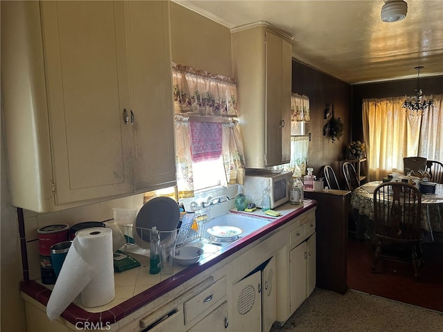 2549 Kansas Ave, South Gate, CA 90280 - kitchen with tile counters, white microwave, white cabinetry, a sink, and decorative light fixtures