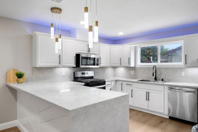 13824 Powers Rd, Poway, CA 92064 - kitchen with appliances with stainless steel finishes, a sink, a peninsula, white cabinets, and light wood-style floors