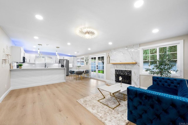 13824 Powers Rd, Poway, CA 92064 - living area featuring healthy amount of natural light, recessed lighting, light wood-type flooring, a high end fireplace, and baseboards