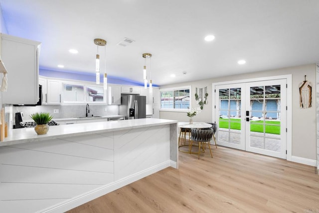 13824 Powers Rd, Poway, CA 92064 - kitchen featuring stainless steel fridge with ice dispenser, a sink, light wood-style floors, white cabinetry, and a peninsula