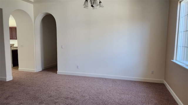 10372 Christo Way, Elk Grove, CA 95757 - spare room featuring arched walkways, light colored carpet, a chandelier, and baseboards