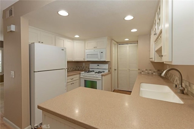 2150 Cheyenne Way Unit 165, Fullerton, CA 92833 - kitchen with white appliances, a sink, a peninsula, recessed lighting, and white cabinets