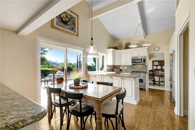 8640 Lindante Dr, Whittier, CA 90603 - dining area featuring beam ceiling, light wood finished floors, and high vaulted ceiling