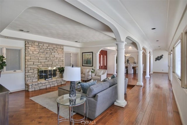 3624 Hollins Ave, Claremont, CA 91711 - living area featuring decorative columns, wood-type flooring, a stone fireplace, and arched walkways