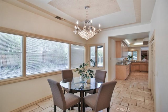 3624 Hollins Ave, Claremont, CA 91711 - dining area with a tray ceiling, stone tile flooring, a chandelier, and baseboards