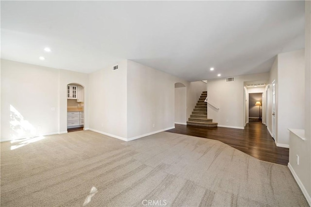 31484 Britton Cir, Temecula, CA 92591 - unfurnished living room with arched walkways, carpet flooring, stairway, baseboards, and recessed lighting