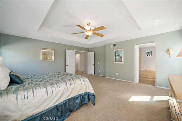 31484 Britton Cir, Temecula, CA 92591 - carpeted bedroom featuring a tray ceiling, baseboards, connected bathroom, a ceiling fan, and arched walkways