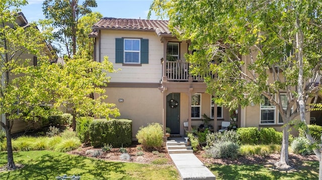 3245 Moss Landing Blvd, Oxnard, CA 93036 - view of front of house with stucco siding, a balcony, a tiled roof, and a front yard