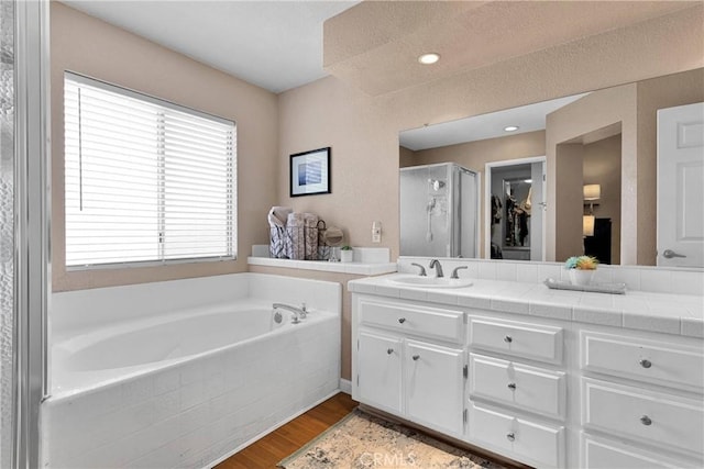 13950 High Falls Trl, Apple Valley, CA 92307 - bathroom featuring a stall shower, double vanity, a bath, and wood finished floors