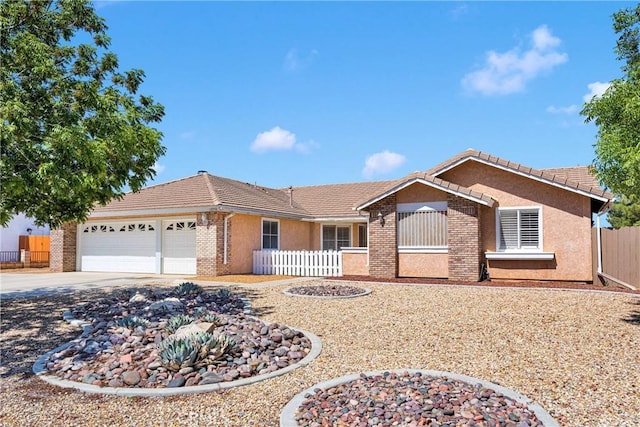 13950 High Falls Trl, Apple Valley, CA 92307 - ranch-style house with an attached garage, a tiled roof, concrete driveway, brick siding, and stucco siding
