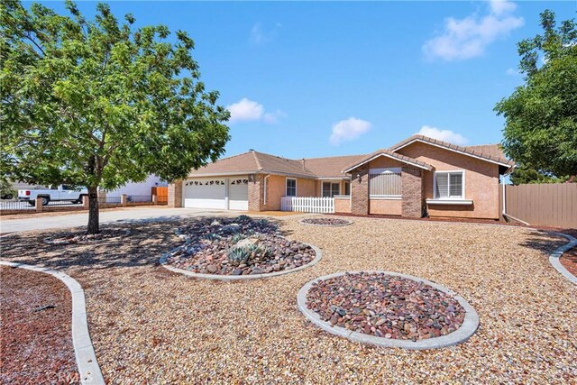 13950 High Falls Trl, Apple Valley, CA 92307 - single story home with a garage, driveway, a tile roof, brick siding, and stucco siding