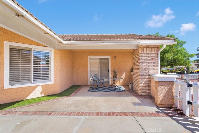 13950 High Falls Trl, Apple Valley, CA 92307 - entrance to property with stucco siding, a patio area, and brick siding
